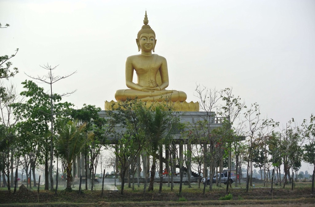 Golden Buddha statue in the middle of the countryside